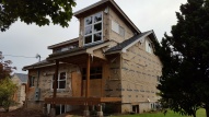 Upper windows in, porch roof complete and decks framed.